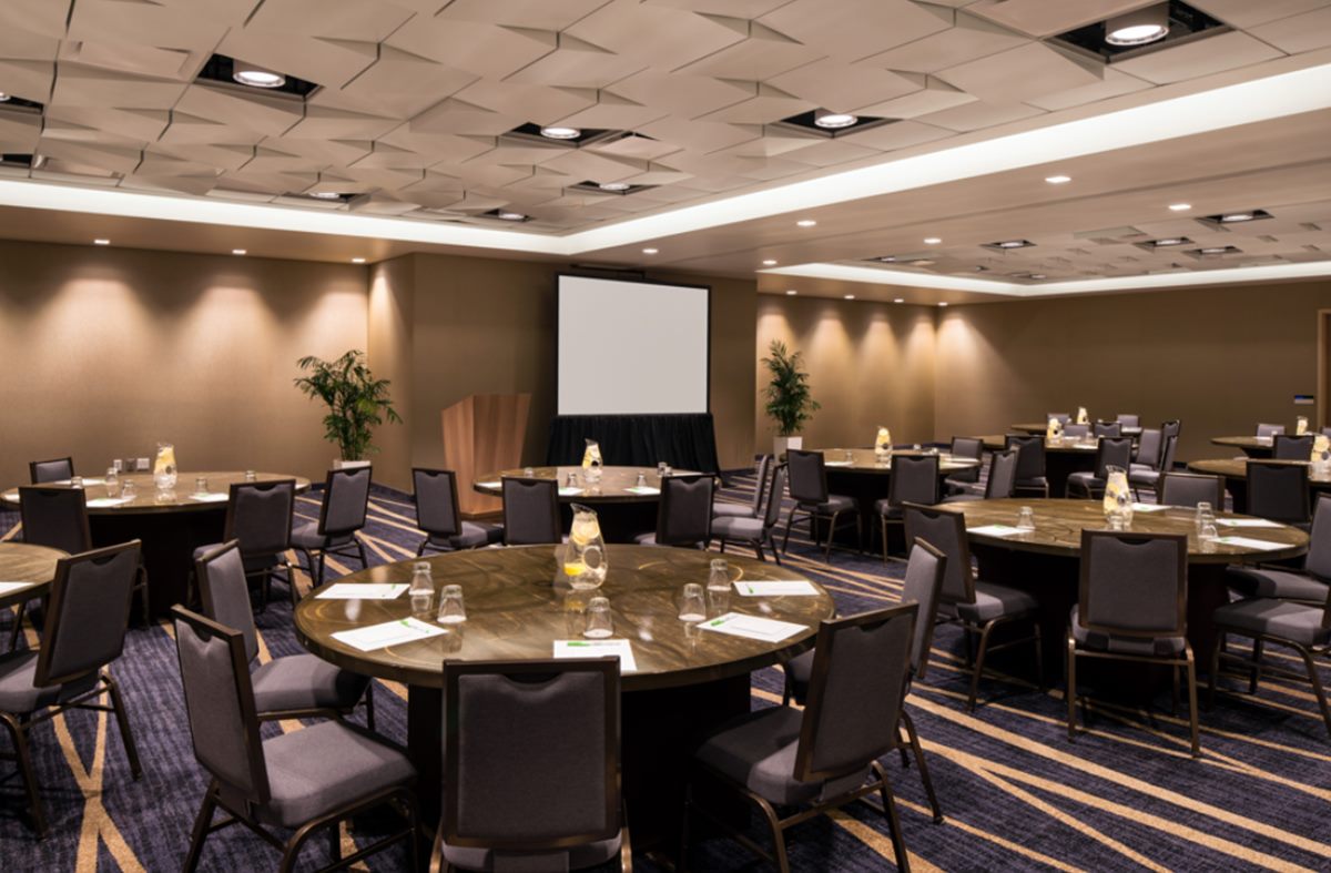 Encanto 1 and 2 ballroom set with round tables facing a screen